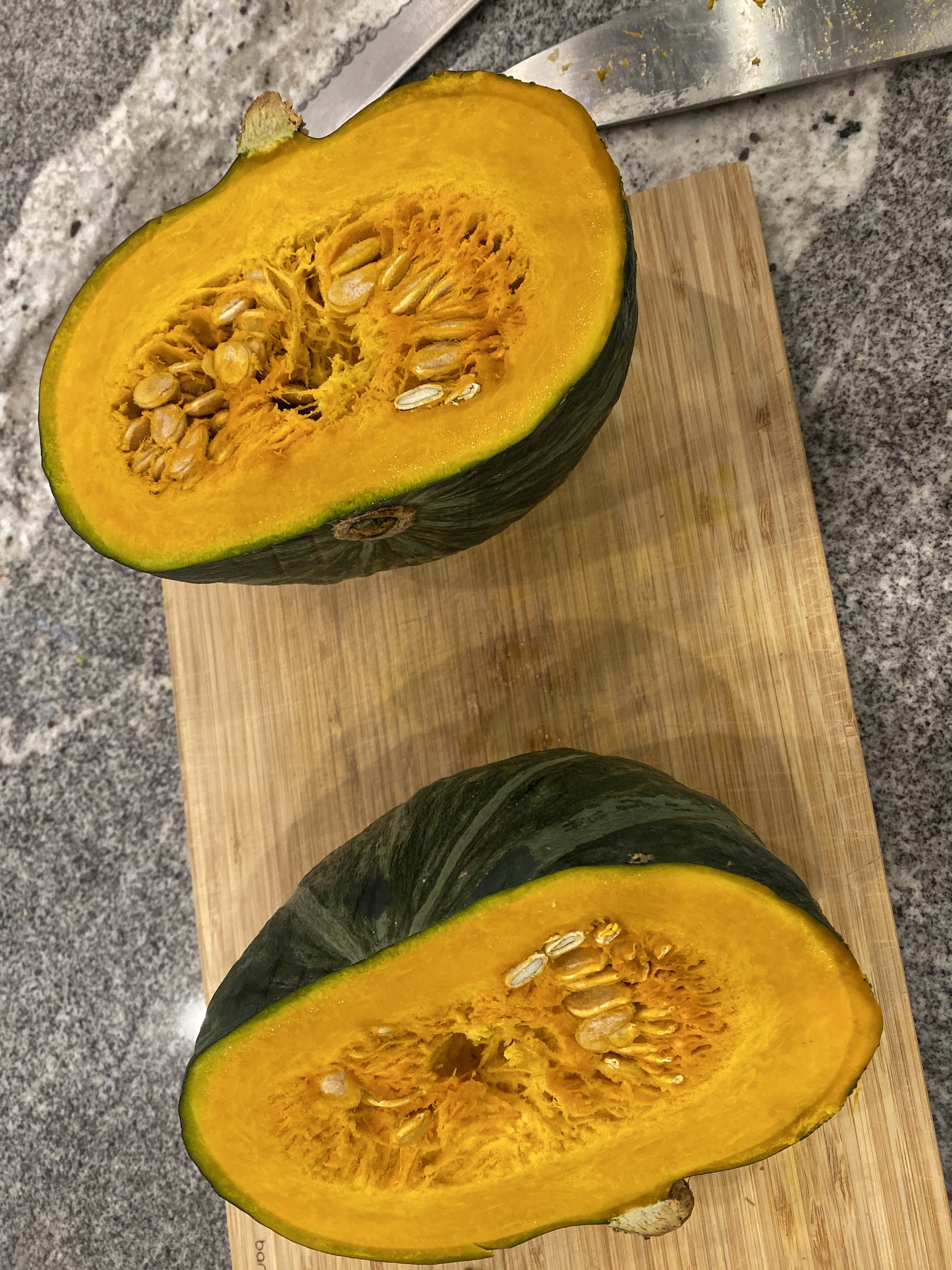 The kabocha has a more centered core, a deep orange flesh, and a rounder shape.
