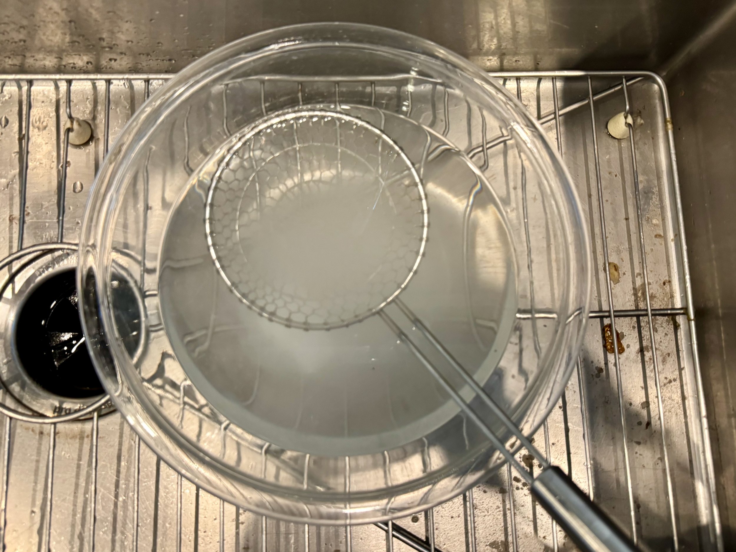 Lye can cause chemical burns, so I use gloves and eye protection and minimize the risk of exposure. Here', I’m using a stainless steel skimmer to dissolve the lye granules.